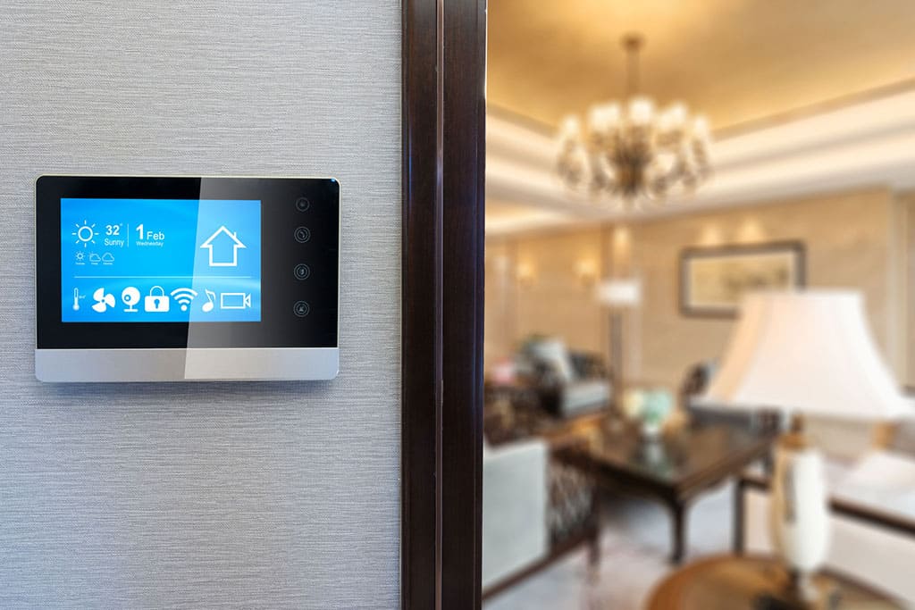 smart thermostat positioned on wall with blurry living area in the background