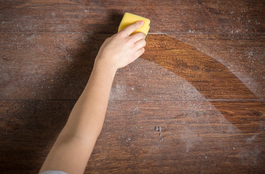 Using yellow sponge for cleaning dusty wood