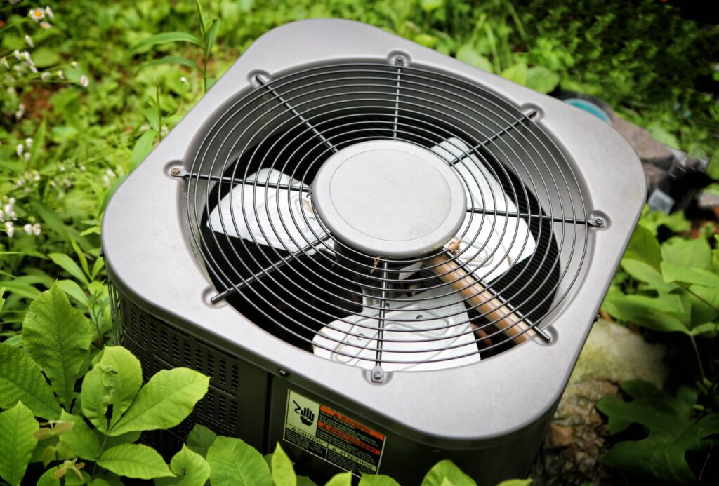 outdoor hvac unit positioned outside surrounded by leaves